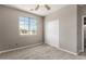 Cozy bedroom with carpet, fan and natural light, adjacent to the en-suite bathroom at 13617 W Crocus Dr, Surprise, AZ 85379