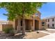 Inviting home exterior features an arched entryway, landscaped yard, and desert landscaping at 13617 W Crocus Dr, Surprise, AZ 85379