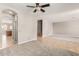Spacious open-concept living room with a ceiling fan, carpet, and tile flooring at 13617 W Crocus Dr, Surprise, AZ 85379
