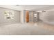 Open living space with carpet and tile flooring and a wooden front door at 13617 W Crocus Dr, Surprise, AZ 85379