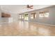 Spacious living room featuring tile floors, large windows, and a ceiling fan for comfortable living at 13617 W Crocus Dr, Surprise, AZ 85379