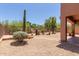 Landscaped backyard featuring desert flora, decorative gravel, and a covered patio for outdoor enjoyment at 14657 N 103Rd Way, Scottsdale, AZ 85255