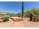 Desert landscape in backyard with a small brick fire pit and scenic views at 14657 N 103Rd Way, Scottsdale, AZ 85255