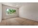 Bright bedroom with carpet flooring and a window overlooking the greenery at 14657 N 103Rd Way, Scottsdale, AZ 85255