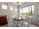 Bright dining area with tile floors features a granite counter and desert views from multiple windows, staged with dining set at 14657 N 103Rd Way, Scottsdale, AZ 85255