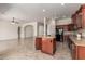 Open concept kitchen with dark wood cabinets, granite countertops, and a functional center island with bar seating at 14657 N 103Rd Way, Scottsdale, AZ 85255