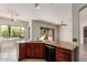Kitchen island with granite countertop, double sink, and wooden cabinets at 14657 N 103Rd Way, Scottsdale, AZ 85255