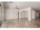 Spacious living area with tile flooring, featuring multiple archways and access to a back patio at 14657 N 103Rd Way, Scottsdale, AZ 85255
