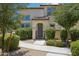 Inviting front entry with landscaped walkway leading to the arched doorway and iron gate at 14870 W Encanto Blvd # 1091, Goodyear, AZ 85395