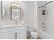 Well-lit bathroom with a modern vanity, round mirror, geometric wallpaper, and a shower-tub combo at 1492 W Bruce Ave, Gilbert, AZ 85233