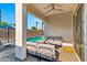 Inviting covered patio with comfortable seating, ceiling fan, and view of the sparkling pool, perfect for relaxation at 1492 W Bruce Ave, Gilbert, AZ 85233