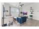 This bright living room features large windows, neutral walls and decor, and wood look tile flooring at 1492 W Bruce Ave, Gilbert, AZ 85233