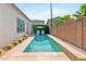 Serene backyard featuring a sparkling pool, lush landscaping, and patio seating, perfect for outdoor relaxation at 1492 W Bruce Ave, Gilbert, AZ 85233