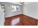 Bright, empty living room with hardwood floors, a ceiling fan, and a large window at 1750 E Mateo Cir # 103, Mesa, AZ 85204