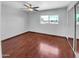 Empty main bedroom with hardwood floors, a ceiling fan, window and closet with sliding mirror doors at 1750 E Mateo Cir # 103, Mesa, AZ 85204