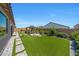 Expansive backyard features manicured artificial turf, a paved walkway, and a cozy gazebo with seating at 17597 W Red Fox Rd, Surprise, AZ 85387