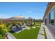 Spacious backyard with artificial turf, a paved patio, gazebo, and a variety of lush landscaping at 17597 W Red Fox Rd, Surprise, AZ 85387