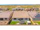 An aerial view of a cozy backyard featuring a green lawn, patio seating, and privacy fencing at 17597 W Red Fox Rd, Surprise, AZ 85387