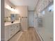 Bathroom featuring a dual sink vanity with white cabinetry and a glass shower at 17597 W Red Fox Rd, Surprise, AZ 85387