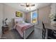 Comfortable bedroom features a ceiling fan, natural light, carpeted flooring, and neutral wall paint at 17597 W Red Fox Rd, Surprise, AZ 85387