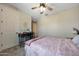 Cozy bedroom featuring a ceiling fan, carpeted floors, and desk with seating, creating a comfortable and functional space at 17597 W Red Fox Rd, Surprise, AZ 85387