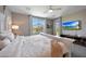 Bedroom with white trim, carpeted floors, a ceiling fan, and a view of the backyard through the window at 17597 W Red Fox Rd, Surprise, AZ 85387