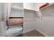 Bright walk-in closet featuring carpet flooring and white storage shelving at 17597 W Red Fox Rd, Surprise, AZ 85387