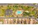 Aerial view showcasing a community pool with lounge chairs, palm trees, and desert landscaping at 17597 W Red Fox Rd, Surprise, AZ 85387