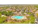 Aerial shot features a community pool surrounded by palm trees, lounge chairs, and desert landscaping at 17597 W Red Fox Rd, Surprise, AZ 85387