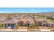 Aerial view of home showcasing desert landscaping, a brick driveway, and a 3-car garage at 17597 W Red Fox Rd, Surprise, AZ 85387