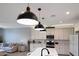 Modern kitchen with white cabinets, stainless steel appliances, a kitchen island with pendant lighting, and tile backsplash at 17597 W Red Fox Rd, Surprise, AZ 85387