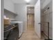 Laundry room with modern washer and dryer, complemented by wood-look tile flooring and ample shelving at 17597 W Red Fox Rd, Surprise, AZ 85387