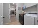 Well-organized laundry area with modern appliances, storage shelves, and convenient access to a walk-in closet at 17597 W Red Fox Rd, Surprise, AZ 85387