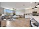 Bright living room with a comfortable sectional sofa, large windows, and a view of the adjacent kitchen and dining area at 17597 W Red Fox Rd, Surprise, AZ 85387