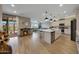 Open-concept living area showcases a kitchen island, fireplace, wood-look tile floors, and seamless indoor-outdoor flow at 17597 W Red Fox Rd, Surprise, AZ 85387