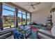 Inviting sunroom with a colorful rug, comfortable seating, and views of the backyard gazebo through large windows at 17597 W Red Fox Rd, Surprise, AZ 85387