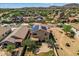 An aerial view showing the house, back patio, and solar panels amidst the desert landscape of the neighborhood at 18132 W Cardinal Dr, Goodyear, AZ 85338