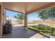View of covered back patio with fire pit, landscaped yard, and outdoor seating area at 18132 W Cardinal Dr, Goodyear, AZ 85338