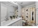 Bathroom featuring a double sink vanity, large mirror, and decorative shower curtain at 18132 W Cardinal Dr, Goodyear, AZ 85338