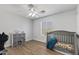 Bedroom features a crib, ceiling fan, and natural light from a window at 18132 W Cardinal Dr, Goodyear, AZ 85338
