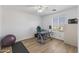 Light-filled bedroom with desk, yoga mat, ceiling fan, and wood-look floors at 18132 W Cardinal Dr, Goodyear, AZ 85338