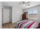 Bright bedroom featuring modern ceiling fan, a window with blinds, and a red and white striped bedspread at 18132 W Cardinal Dr, Goodyear, AZ 85338