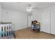 Bedroom with crib, ceiling fan, and closet with sliding doors at 18132 W Cardinal Dr, Goodyear, AZ 85338