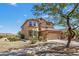Charming two-story home with a tan facade, tiled roof, desert landscaping, and an attached two car garage at 18132 W Cardinal Dr, Goodyear, AZ 85338
