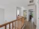 Upstairs hallway with wood floors, a view to a bathroom, and an open bedroom at 18132 W Cardinal Dr, Goodyear, AZ 85338