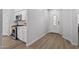 Bright, charming kitchenette features white cabinetry, tile backsplash, stainless steel appliances, and luxury vinyl plank flooring at 18132 W Cardinal Dr, Goodyear, AZ 85338