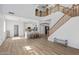 Open-concept living room with a view into the kitchen and a staircase with wooden railings at 18132 W Cardinal Dr, Goodyear, AZ 85338