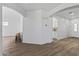 Spacious living area with wood laminate flooring, white walls and trim, and archways leading to other rooms at 18132 W Cardinal Dr, Goodyear, AZ 85338