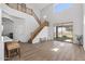 Bright living room featuring a grand staircase, natural light, and wood-look floors at 18132 W Cardinal Dr, Goodyear, AZ 85338