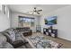 Spacious living room with large window, modern ceiling fan, and wall-mounted television at 18132 W Cardinal Dr, Goodyear, AZ 85338